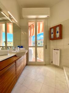 a bathroom with two sinks and a large window at Maison de Mauri in San Terenzo