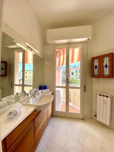 a bathroom with two sinks and a large mirror at Maison de Mauri in San Terenzo
