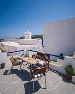 a patio with a table and chairs on a roof at GIAMAKI APARTMENTS in Sifnos