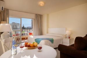 una habitación de hotel con una cama y una mesa con un bol de fruta en Apartamentos Nucleo Cristal, en Torremolinos