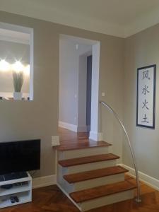 a living room with a staircase and a television at Appartment Sonneck in Freiburg im Breisgau +3 photos