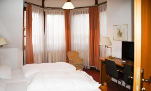 ein Schlafzimmer mit einem Bett und einem Schreibtisch mit Computer in der Unterkunft Hotel Sonne in Lorch