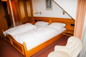 two twin beds in a room with a chair at Hotel Sonne in Lorch