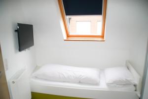 Habitación con espejo y cama con almohadas blancas. en Hotel Sonne en Lorch