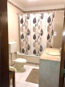 a bathroom with a toilet and a shower curtain at Cascais Spacious Getaway in Cascais