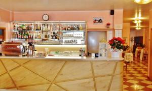 Hotel Ristorante Al Bassanello في باسّانو ديل غرابّا: بار في مطعم مع ساعة على الحائط