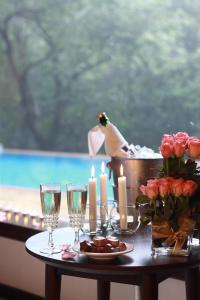 - une table avec des bougies, des verres à vin et une table avec des roses dans l'établissement The IBNII - Eco Luxury Resort, à Madikeri