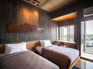 a bedroom with two beds and a window at Navakitel Design Hotel in Nakhon Si Thammarat