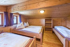 1 dormitorio con 2 camas en una cabaña de madera en Almliesl STVE-551, en Sankt Veit im Pongau