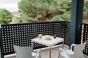 a white table and chairs on a balcony with a view at Pensión La Buena Vida in Caspe