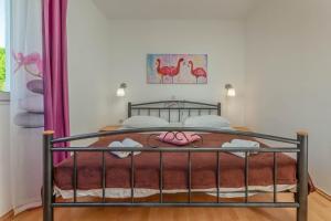 ein Schlafzimmer mit einem Bett mit rosa Schuhen darauf in der Unterkunft Luka 2 in Podgora