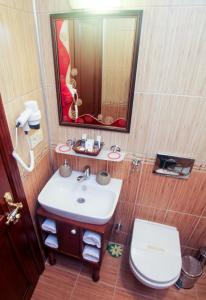 a bathroom with a sink and a toilet and a mirror at Esans Hotel - Special Category in Istanbul