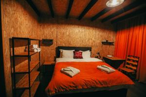 - une chambre avec un lit et une couverture rouge dans l'établissement Wooden Hotel Kazbegi, à Kazbegi