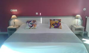 PouldreuzicにあるHotel Restaurant Le Capricorneのベッドルーム(白い大型ベッド、ランプ2つ付)