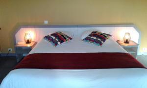 PouldreuzicにあるHotel Restaurant Le Capricorneのベッドルーム1室(大型ベッド1台、枕2つ付)