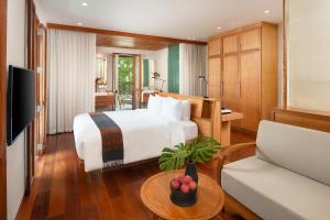 a hotel room with a bed and a table at Avani+ Luang Prabang Hotel in Luang Prabang