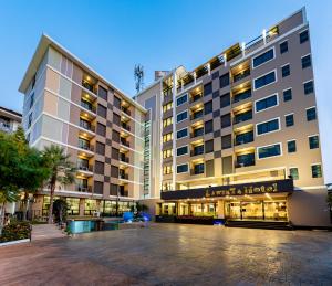 a hotel building with a parking lot in front of it at LawinTa Hotel Pattaya in Jomtien Beach