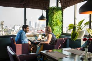 un homme et une femme assis à une table dans un restaurant dans l'établissement Serene Boutique Hotel & Spa, à Hanoï
