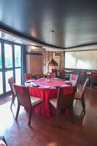uma sala de jantar com uma mesa vermelha e cadeiras em The Classic Hotel em Imphal