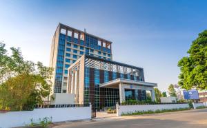 德里久尔Hyatt Regency Thrissur的街道前方有蓝色窗户的高楼