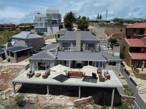 eine Luftansicht eines Hauses mit Stühlen und Sonnenschirmen in der Unterkunft The Lookout Guest House in Mossel Bay