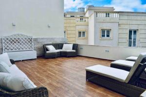 eine Dachterrasse mit Stühlen und Sofas auf einem Gebäude in der Unterkunft Modern Luxury villa in St. Julians in St Julian's