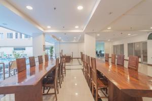 a large wooden table and chairs in a room at RedDoorz Apartment @ Emerald Towers Bandung in Bandung