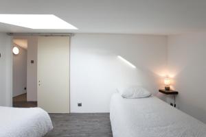 two beds in a room with white walls at Gîte du Charme Provençal in Sénas