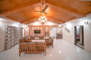 ein Wohnzimmer mit einem Deckenventilator und einem Sofa in der Unterkunft Highgarden Villa in Mahabaleshwar