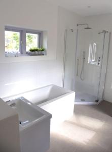 a white bathroom with a sink and a shower at Spring Cottage in Amberley