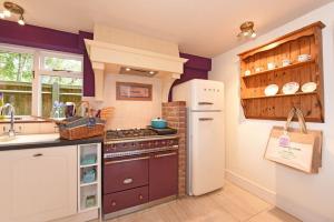 a kitchen with a refrigerator and a stove and a sink at Spring Cottage in Amberley