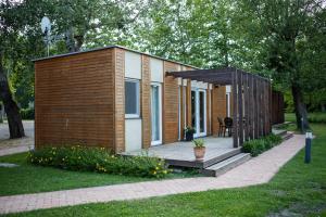 um pequeno chalé com um deque de madeira num parque em Zsanett Hotel em Balatonkeresztúr