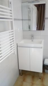 a white bathroom with a sink and a mirror at BOYRIE Daniel et Hélène in Gavarnie