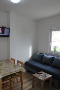 a living room with a blue couch and a table at Villa Marina in Omiš