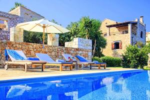 a swimming pool with lounge chairs and an umbrella at Strofilia Villas Crete in Sellía