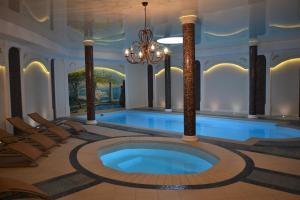 a swimming pool in a room with a chandelier at Borowinowy Zdrój Hotel Wellness Spa & Conference in Supraśl