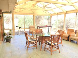 a dining room with a glass table and chairs at Fox Farm - Entire House Sleeps 12 ppl in Lenswood