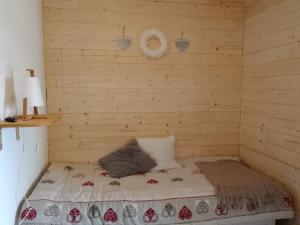um pequeno quarto com uma cama num quarto de madeira em Bel appartement cosy - PIED DES PISTES avec local à ski - 6 personnes em Montclar