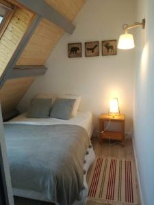 una camera con letto e tavolo con lampada di Bel appartement cosy - PIED DES PISTES avec local à ski - 6 personnes a Montclar