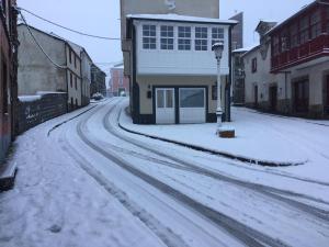 a snow covered street in a town with a building at Casa Marentes in Fonsagrada