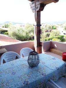 a table with a blue table cloth on a balcony at Bilocale Li Menduli in San Teodoro