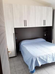 a bedroom with a bed and white cabinets at Bilocale Li Menduli in San Teodoro