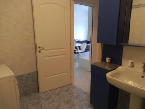 baño con puerta blanca y lavamanos en Il Tulipano, en Bérgamo