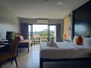 a hotel room with two beds and a desk and a window at Amarin Samui Hotel - SHA Plus Certified in Mae Nam