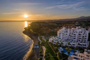 エステポナにあるBahía Boutique Apartmentsの夕日の水辺の空中の街並み