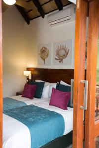 a bedroom with two beds with purple and blue pillows at Kruger Park Lodge Unit No. 608B in Hazyview