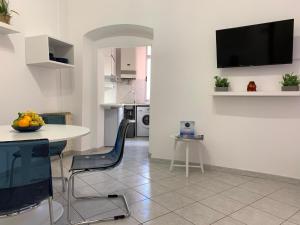 a kitchen with a table and chairs and a tv on a wall at House Carruggio by Holiday World in Sestri Levante
