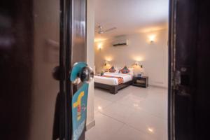 Una puerta a un dormitorio con una cama en una habitación en FabHotel Anutham Saket, en Nueva Delhi