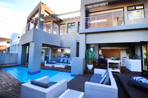 a house with a swimming pool in front of it at C' la Vie Luxury Accommodation in Melkbosstrand