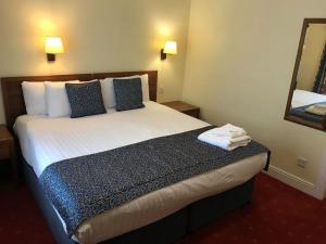 a hotel room with a large bed with a mirror at The Celtic Royal Hotel in Caernarfon